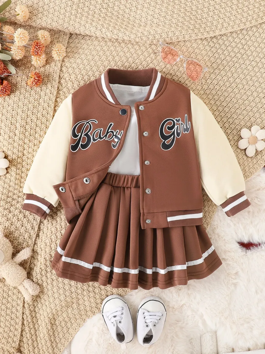 Offrez à votre petite princesse un look tendance et adorable avec cet ensemble composé d’une veste style universitaire et d’une jupe plissée assortie. Confortable et élégant, il est parfait pour toute